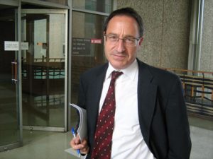 Daniel Horowitz in front of courthouse holiding file for chiropractic fraud case